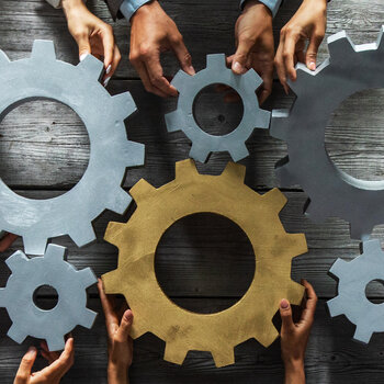 Business people joining gears